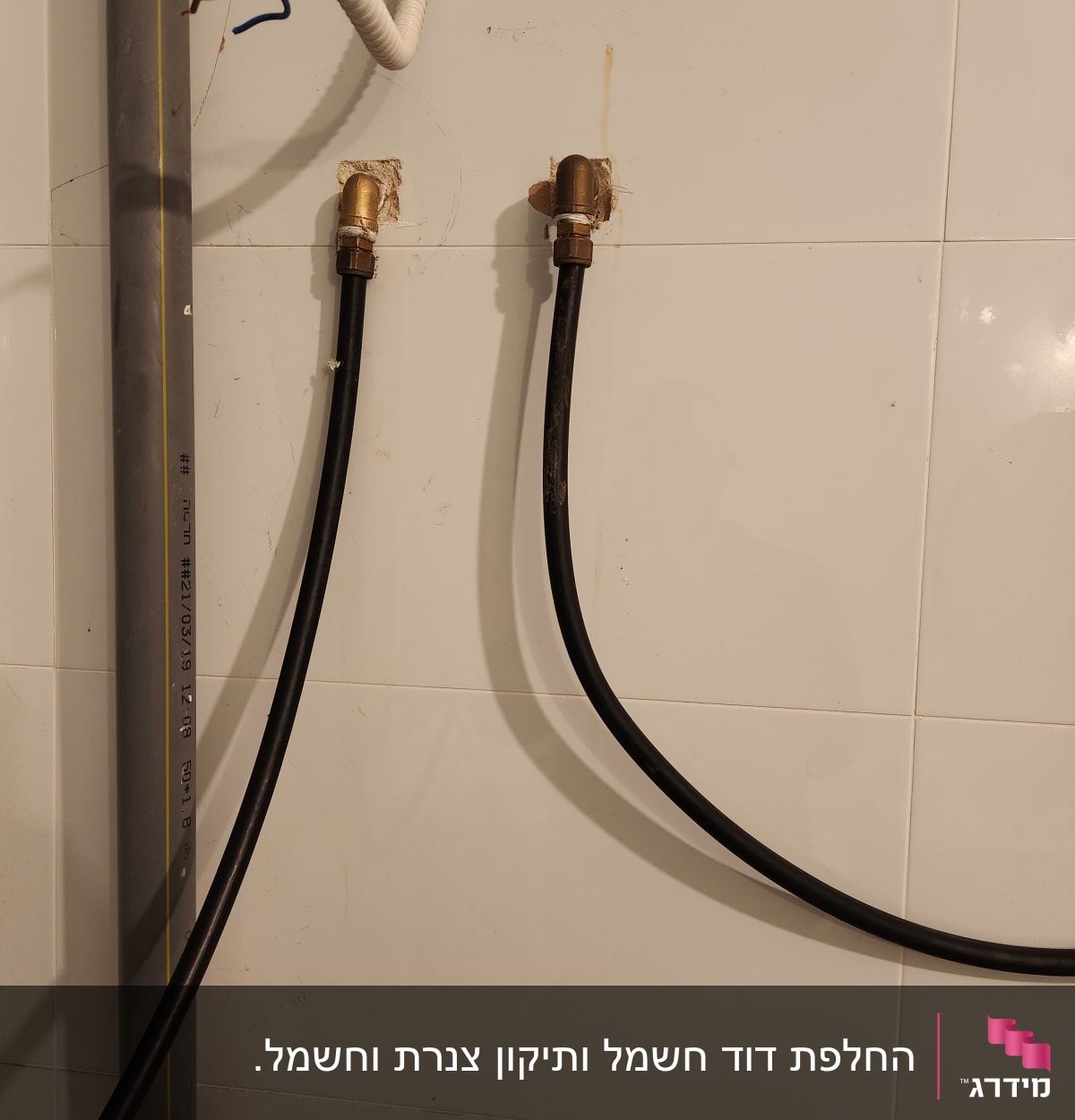 צינורות שחורים מחוברים לקיר עם מחברים מתכתיים